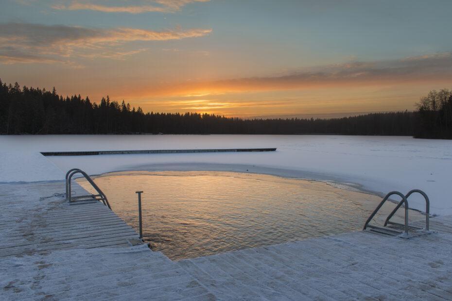 Piscina natural em lago congelado, com sol se pondo ao fundo. Local ideal para um afterdrop.