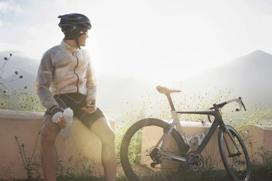 Ciclista descansando enquanto admira paisagem. Testando a sua dose mínima efetiva de treinamento.